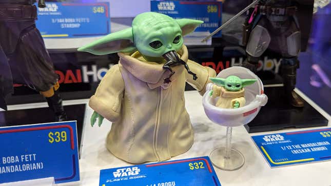 A toy of Baby Yoda eats a creature.