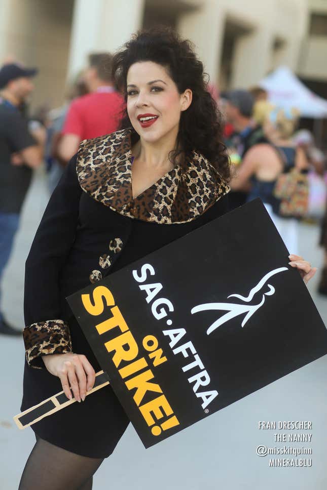 A cosplayer holds a SAG-AFTRA strike sign while dressed as Fran Drescher's character from the '90s sitcom The Nanny.