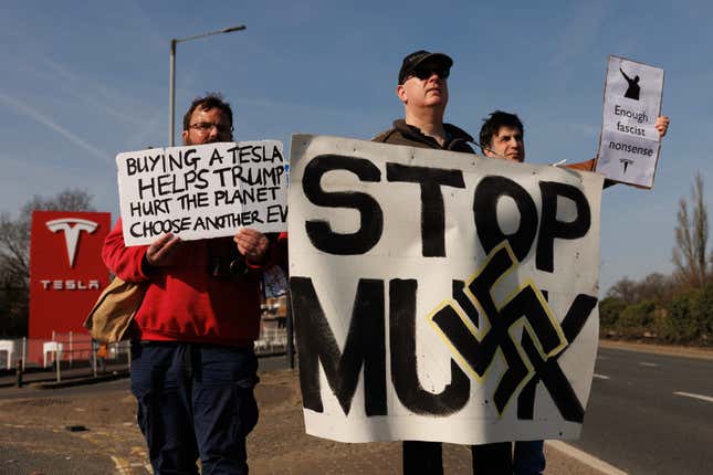 Protesters stands outside a Tesla showroom in West London during a “Tesla Takedown” protest on March 08, 2025 in London, England.