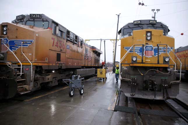 FILE - A Union Pacific worker walks between two locomotives that are being serviced in a railyard in Council Bluffs, Iowa, on Dec. 15, 2023. Union Pacific reports earnings on Thursday, April 25, 2024. (AP Photo/Josh Funk)