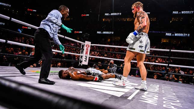 YouTube personality Jake Paul (R) knocks out former UFC welterweight champion Tyron Woodley in an eight-round cruiserweight bout at the Amalie Arena in Tampa, Florida, on December 18, 2021. (Photo by CHANDAN KHANNA / AFP) 
