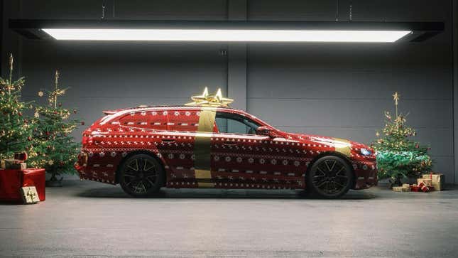 Side view of a BMW M5 Touring with a red Christmas wrap