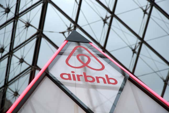 Airbnb logo on a little mini pyramid under the glass Pyramid of the Louvre museum in Paris, France.