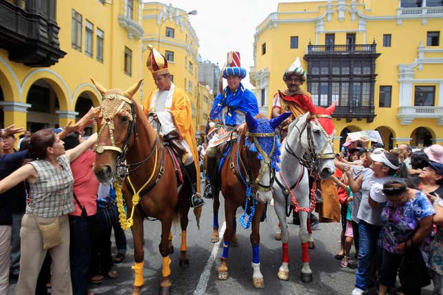 Policemen dressed as Melchor, Balthasar and Gaspar ride horses as they greet people during the celebration of Epiphany