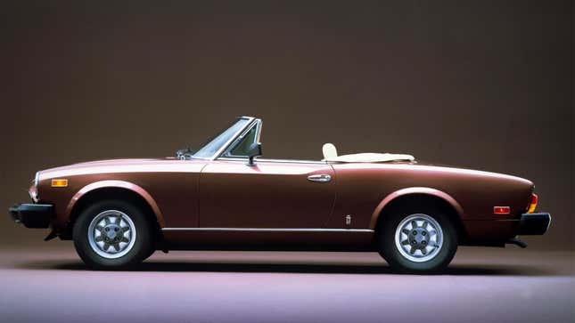 A photo of a brown Fiat Spider convertible taken in a studio. 