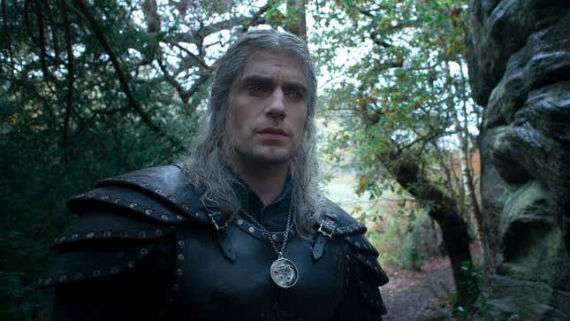 Henry Cavill's Geralt of Rivia wanders through a forest in a scene from The Witcher season 2.