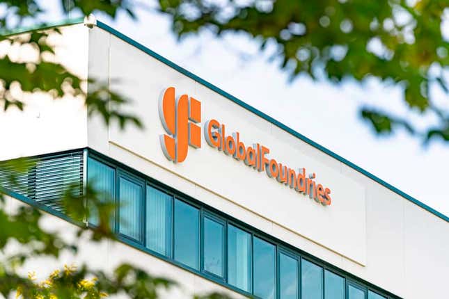 GlobalFoundries logo on corner of building, blurred branches on the edges of photo