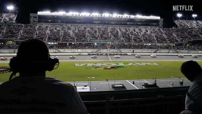 A screenshot from the promo video of the new series showing the view from a pit box looking at all the cars passing on the track