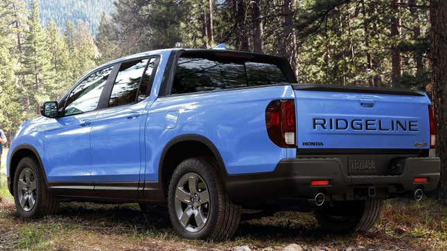 A blue Ridgeline parked in the woods