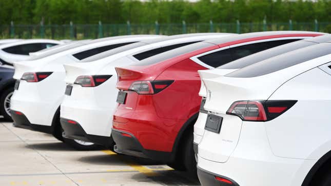A photo of the rear quarter on a line of Tesla EVs. 