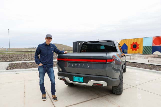 CEO RJ Scaringe stands outside Rivian Automotive’s electric vehicle factory in Normal, Indiana. The facility laid off 100 workers last month ahead of a scheduled factory retooling.