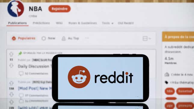 A phone bearing Reddit's logo in front of a screen showing the NBA reddit page.