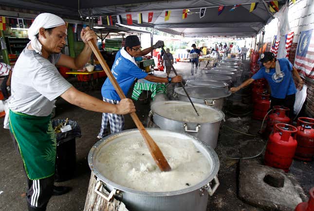 FILE - Malaysian Muslims cook large pots of Bubur Lambuk porridge in the Kampung Baru village in Kuala Lumpur, Malaysia on June 1, 2017. Malaysia&#39;s government said Monday, Oct. 2, 2023, the country that enough rice is available and urged people not to hoard locally produced rice after recent panic-buying led to empty shelves in supermarkets and grocery stores nationwide. (AP Photo/Daniel Chan, File)