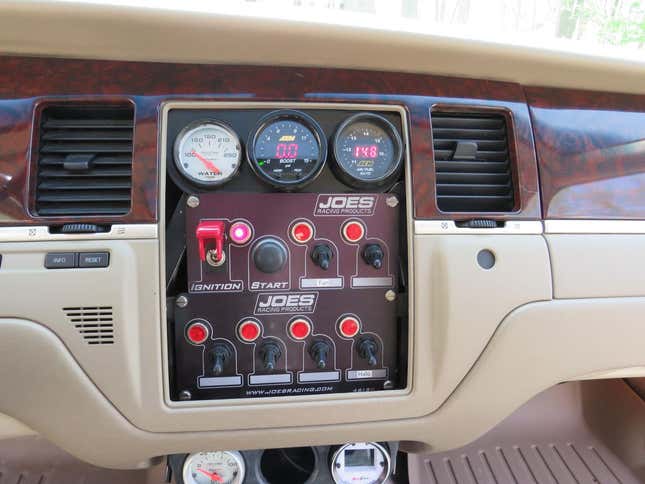 A photo of the center stack in the town car with all aftermarket gauges and switches