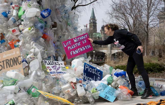 FILE - Activist Dianne Peterson places a sign on an art installation outside a United Nations conference on plastics, April 23, 2024, in Ottawa, Ontario. (Adrian Wyld/The Canadian Press via AP. File)