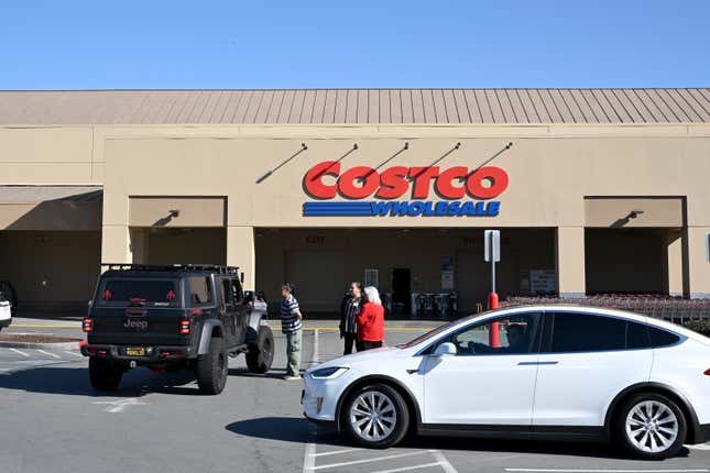 Workers talk with customers about power outages outside a closed Costco in Foster City, California on January 16, 2025. 