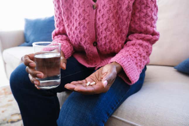 Black woman holding pills