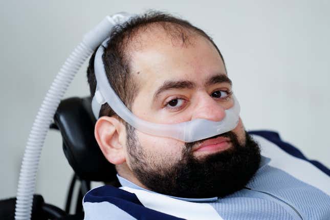 Temple University doctoral student Jaggar DeMarco poses for a photograph while utilizing a battery powered ventilator in Philadelphia, Wednesday, March 6, 2024. DeMarco waited more than three years to get his second ventilator from his health insurer. “Breathing is not a luxury,&quot; he said. “It’s really the bare minimum, and that’s what we’re asking for.” (AP Photo/Matt Rourke)