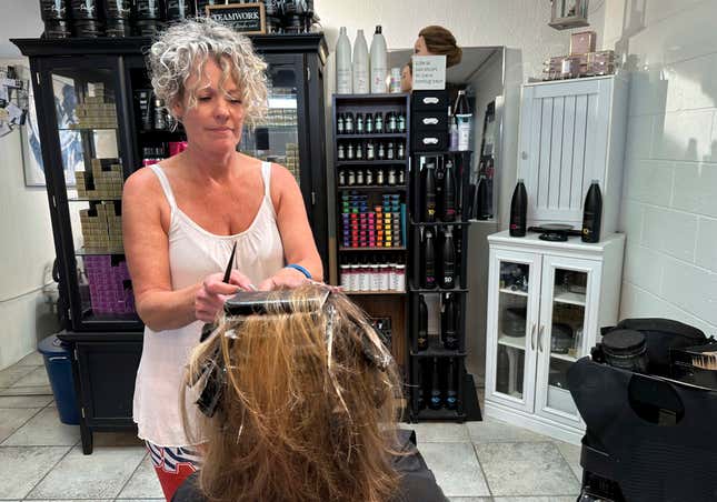 FILE - Christine Geiger cuts a customer&#39;s hair at her salon, July 12, 2023, in Traverse City, Mich. The hair salon is facing a discrimination charge from the state&#39;s Department of Civil Rights after Geiger posted on social media earlier this year that anyone identifying as other than a man or a woman is not welcome at her business. (AP Photos/John Flesher, file)