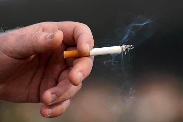 FILE - A man holds a lit cigarette while smoking, Dec. 2, 2020, in San Francisco. Brookline, Mass., has adopted an unusual smoking ban that bars tobacco sales to anyone born in the 21st century. The bylaw — the first of its kind in the country — was adopted by Brookline in 2020 and on Friday, March 8, 2024, was upheld by the state’s highest court, opening the door for other communities to adopt similar bans that will, decades from now, eventually ban all future generations from buying tobacco. (AP Photo/Jeff Chiu, File)