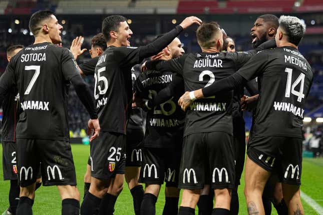 Lens&#39; Kevin Danso celebrates with team mates after scoring his side&#39;s third goal during the French League One soccer match between Lyon and Lens at the Groupama stadium, outside Lyon, France, Sunday, March 3, 2024. (AP Photo/Laurent Cipriani)