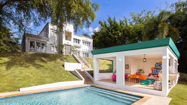 An outdoor shot of Daddy Yankee's home in Puerto Rico. A pool and accompanying pool house is shown.