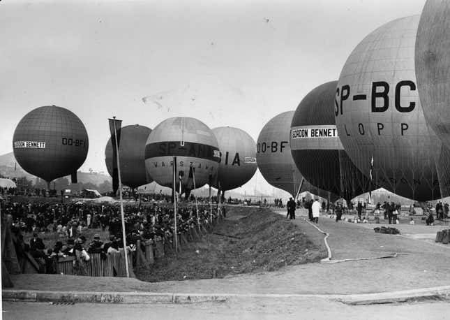 circa 1920: Hot air balloons about to take off. The name Gordon Bennett, a wealthy American journalist who was a sponsor of ballooning, is clearly displayed on two of them.