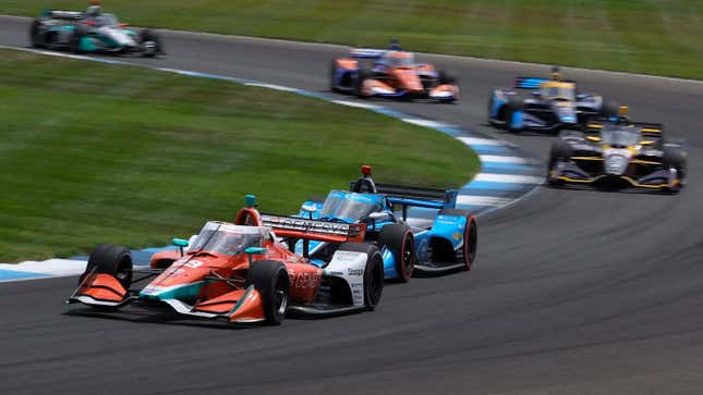 IndyCars race around a corner 