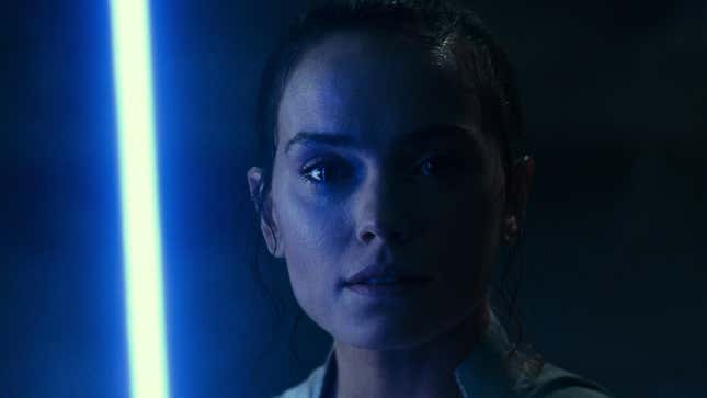 Rey standing with a blue lightsaber.