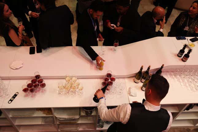 A waiter pours glasses of wine at the Gala reception ahead of the WEF.