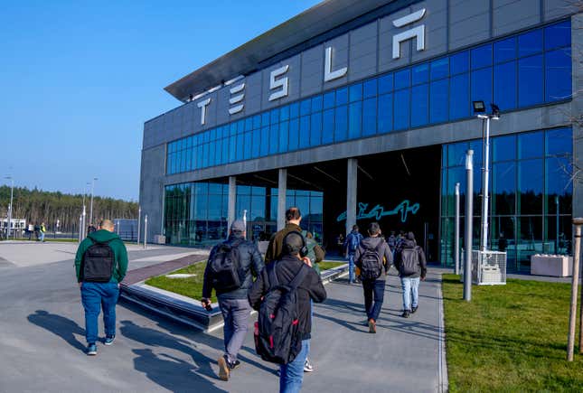 FILE - People walk to the Tesla Gigafactory for electric cars in Gruenheide near Berlin, Germany,March 13, 2024. After reporting dismal first-quarter sales, Tesla is planning to lay off about a tenth of its workforce as it tries to cut costs, multiple media outlets reported Monday. (AP Photo/Ebrahim Noroozi, File)