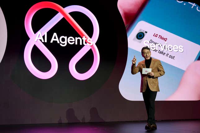 a man wearing a black outfit and beige blazer in front of a backdrop on stage that says AI agents and Services