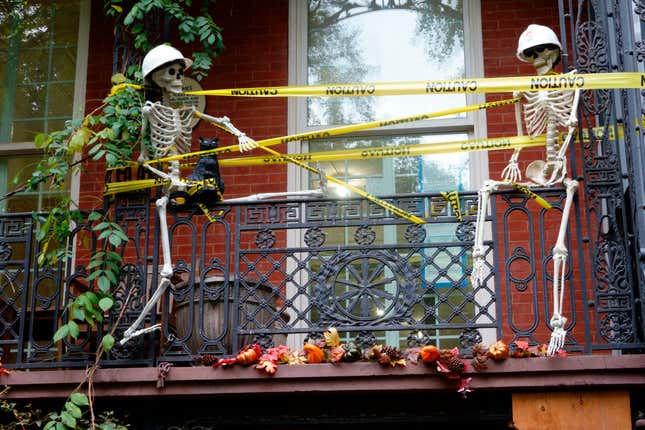 Outside of house decorated with two skeletons for Halloween. 
