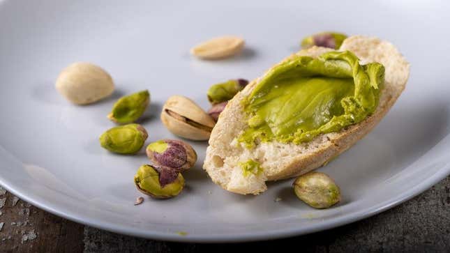 Pistachio spread on piece of bread on plate