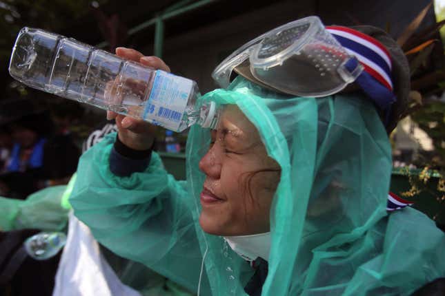 A protestor washes tear gas out of her eyes.
