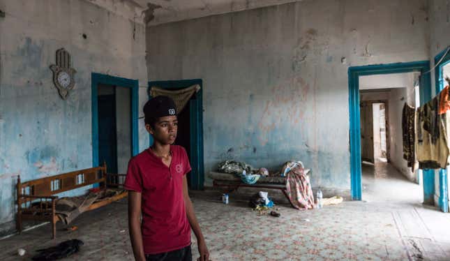 A boy looks in the abandoned house he squats in with his family in Hamam Lif, a suburb just south of Tunis. Skyrocketing prices since the revolution of 2011 have forced families like his to the margins.