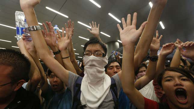 Protesters chant slogans in front of the police during a confrontation after a rally for the October 1 "Occupy Central" civil disobedience movement in Hong Kong September 27, 2014. Over 100 pro-democracy students stormed Hong Kong government headquarters and scuffled with police late on Friday in protest against the Chinese government's tightening grip on the former British colony