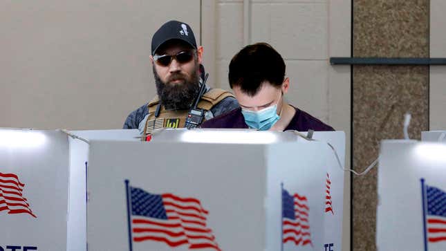 Image for article titled ‘Poll Watching Is Not Voter Intimidation,’ Trump Supporter Whispers Into Ear Of Man Filling Out Ballot In Voting Booth