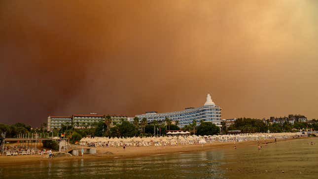 Dark smoke drifts over a hotel complex during a massive forest fire which engulfed a Mediterranean resort region on Turkey's southern coast near the town of Manavgat, on July 29, 2021.