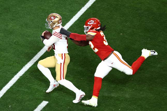 LAS VEGAS, NEVADA - FEBRUARY 11: Nick Bolton #32 of the Kansas City Chiefs tries to tackle Brock Purdy #13 of the San Francisco 49ers in the second quarter during Super Bowl LVIII at Allegiant Stadium on February 11, 2024 in Las Vegas, Nevada. (Photo by Tim Nwachukwu/Getty Images)