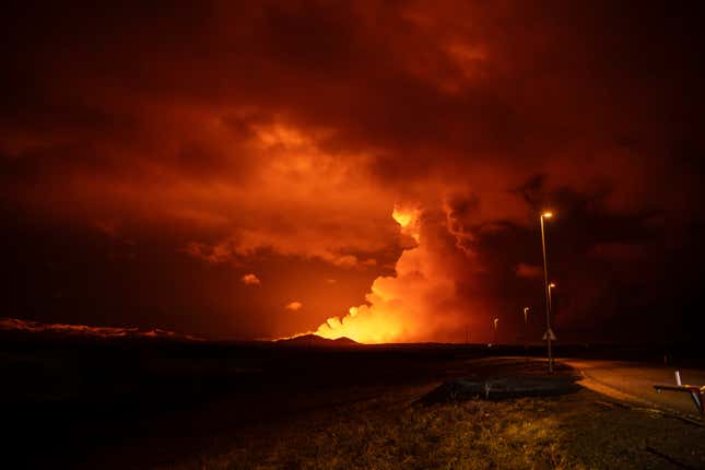 Smoke illuminated by a lava flow.