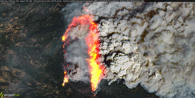 A satellite image of the Caldor Fire burning near Lake Tahoe with a thick plume of smoke.