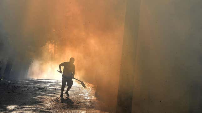 A local resident runs to fight a fire in Thrakomakedones, near Mount Parnitha, north of Athens, Greece, on August 7, 2021. 