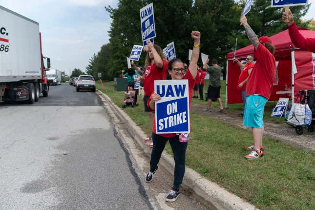 Kim Larson, who works at the Belvidere Assembly Plant, pickets with other members of the United Auto Workers outside the Chrysler Parts Distribution plant Friday, Sept. 22, 2023, in Naperville, Ill. The United Auto Workers union expanded its strike against major carmakers Friday, walking out of 38 General Motors and Stellantis parts-distribution centers in 20 states. (AP Photo/Erin Hooley)