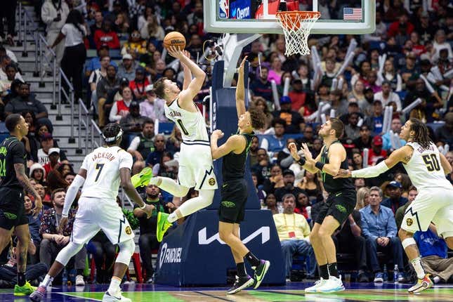 Nov 17, 2023; New Orleans, Louisiana, USA;  Denver Nuggets guard Christian Braun (0) shoots a jump shot against New Orleans Pelicans guard Dyson Daniels (11) during the second half at the Smoothie King Center.