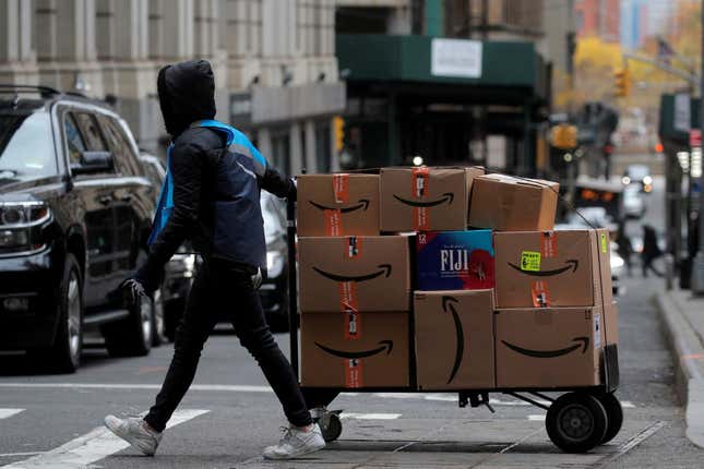 Amazon delivery worker pulls cart of packages