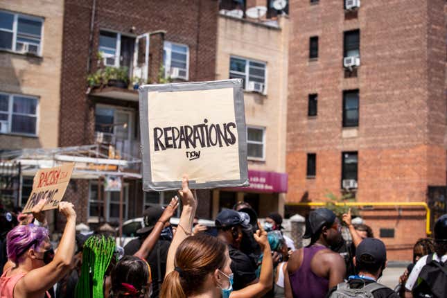 BAYSIDE, NY - AUGUST 01: A large crowd of protesters wearing masks and carrying signs that say, “Reparations Now” as they walk through neighborhoods at the Black Lives Matter protest in Bayside, Queens. 