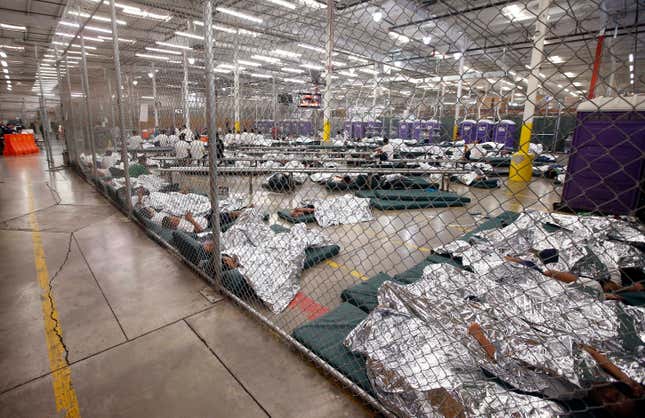 Detainees sleep and watch television in a holding cell.