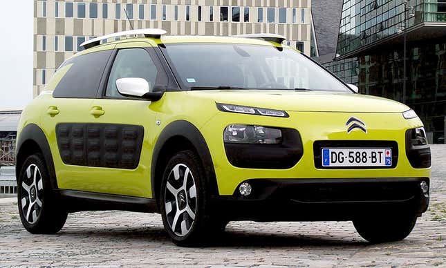 A yellow citroen C4 cactus parked on cobblestone