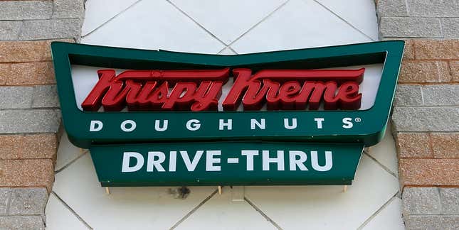 FILE - A Krispy Kreme Doughnuts sign is shown on Aug. 11, 2017, in Miami. More and more businesses are taking advantage of the total solar eclipse set to dim skies across North America on Monday, April 8, 2024. In the snacks department alone, Krispy Kreme is teaming up with Oreo to sell a limited doughnut-cookie creation. Sonic Drive-In is selling a “Blackout Slush Float.” (AP Photo/Alan Diaz, File)